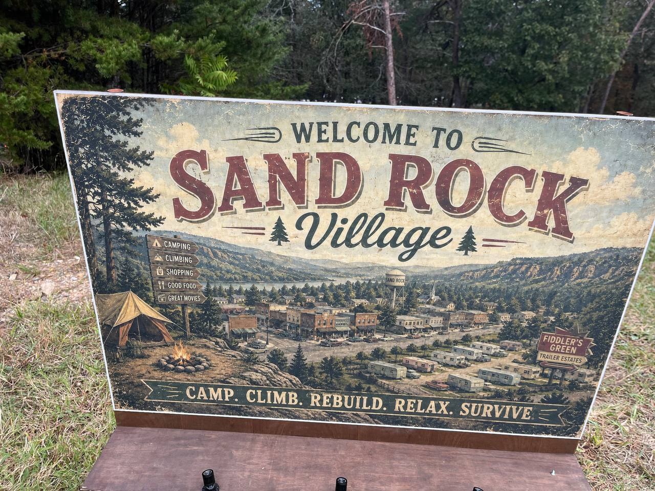 Welcome to Sand Rock Village sign — Camp. Climb. Rebuild. Relax. Survive.