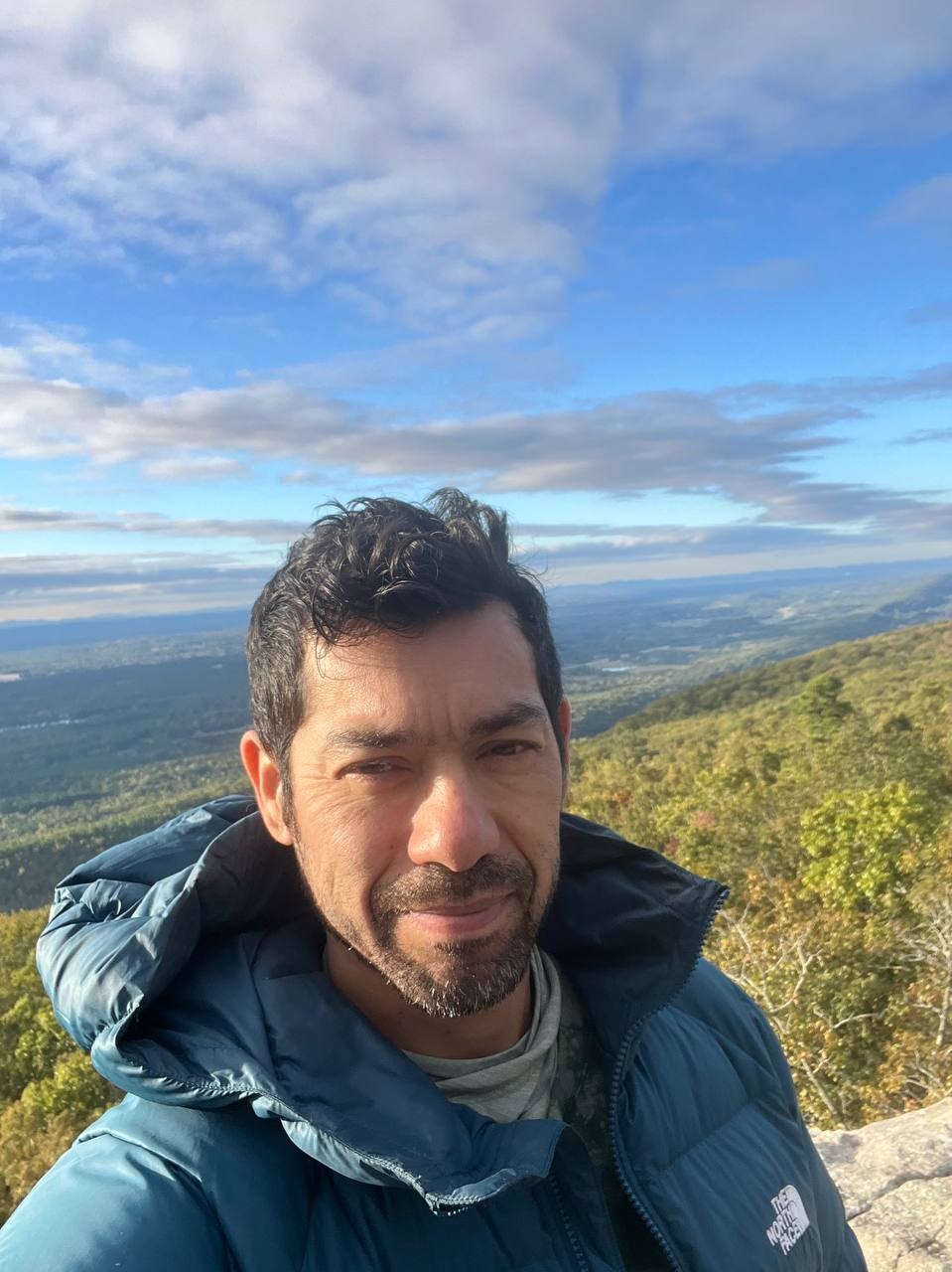 Summit selfie over the forested ridgeline