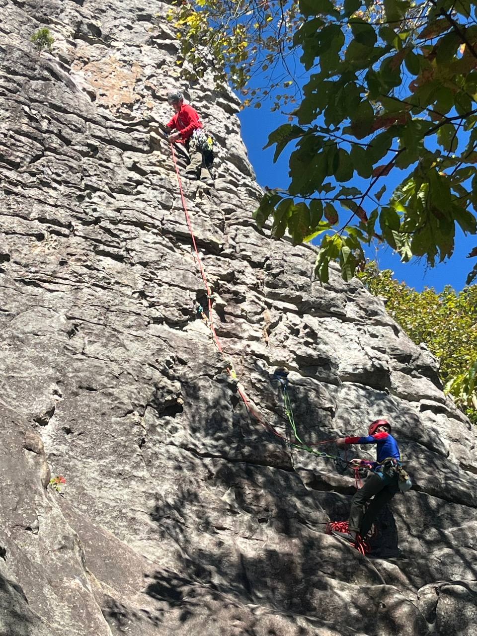 Two climbers on the cliff, ropes running through the cracks
